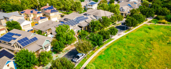 Aerial view of residential community with solar panels on rooftops, highlighting clean energy solutions by Sun Energy Today.