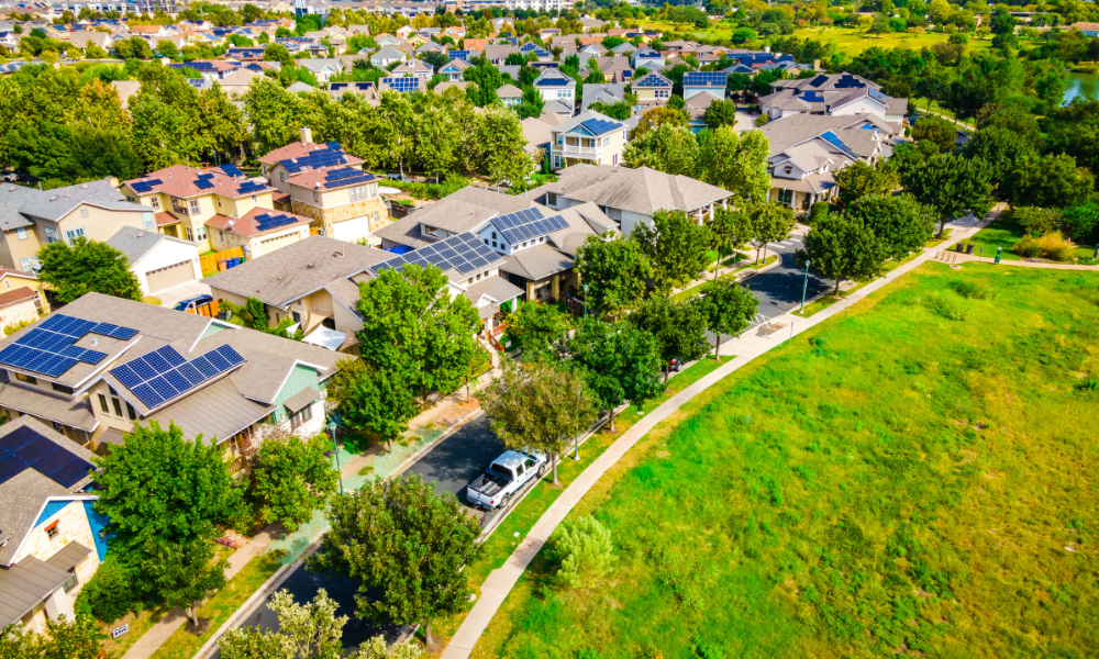 Aerial view of residential community with solar panels on rooftops, highlighting clean energy solutions by Sun Energy Today.