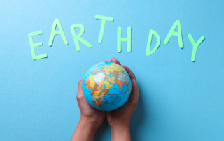 Hands holding globe with Earth Day text on blue background representing sustainable living eco friendly home tips and environmental awareness